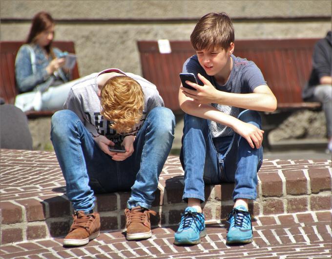 Två pojkar med mobiler